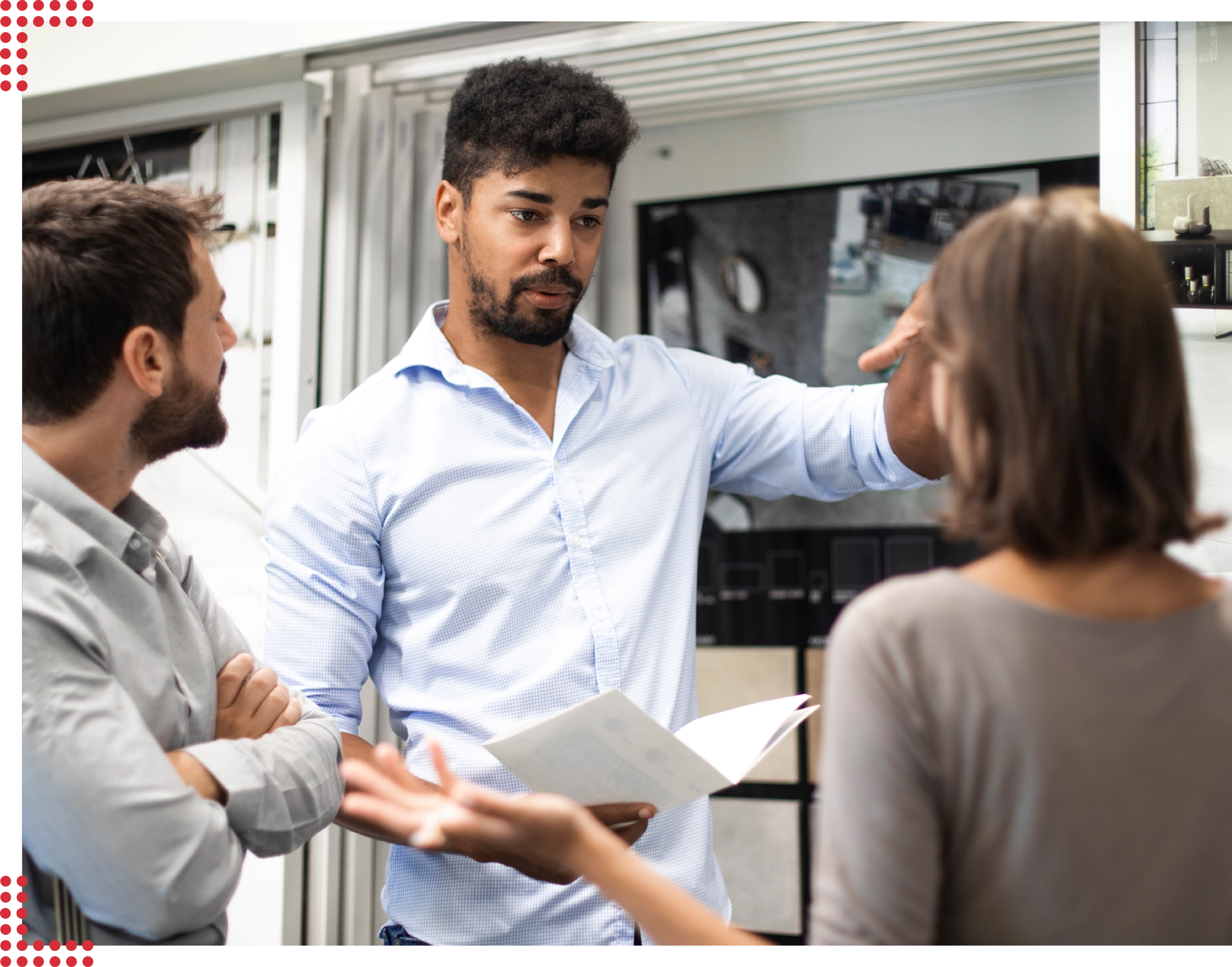 Drei Personen unterhalten sich konzentriert zusammen in einem sauberen und ordentlichen Verkaufsraum