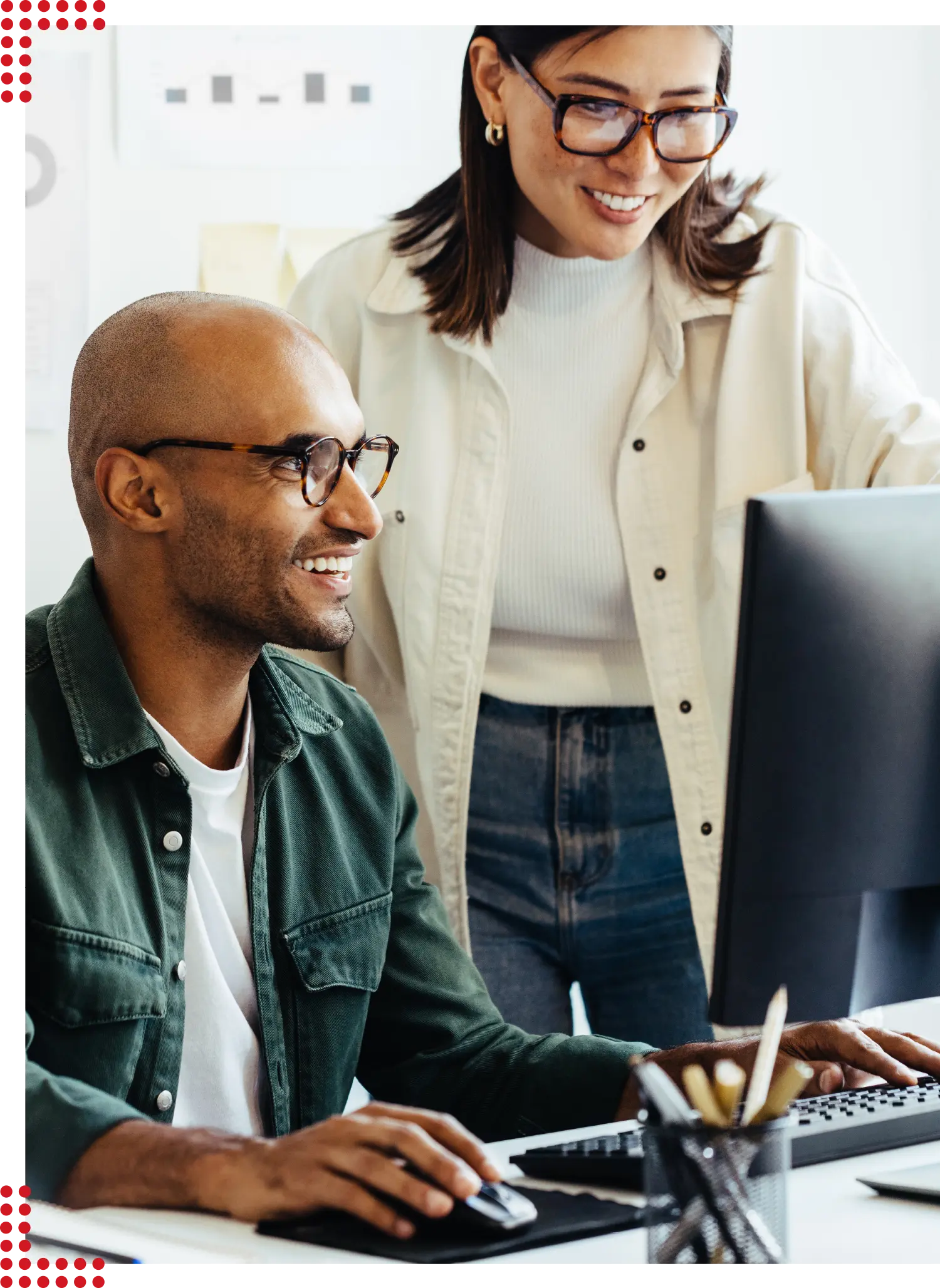 Zwei Personen, die fröhlich zusammenarbeiten und schick gekleidet in einem modernen und hellen Büro sind