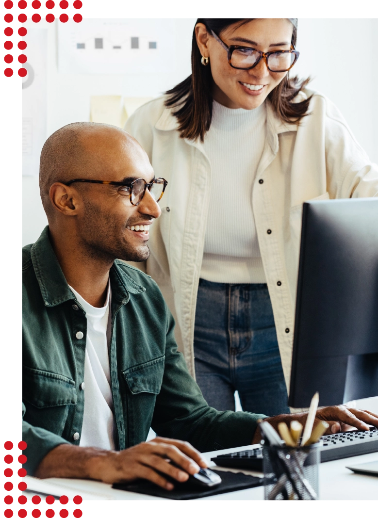 Zwei Personen, die fröhlich zusammenarbeiten und schick gekleidet in einem modernen und hellen Büro sind